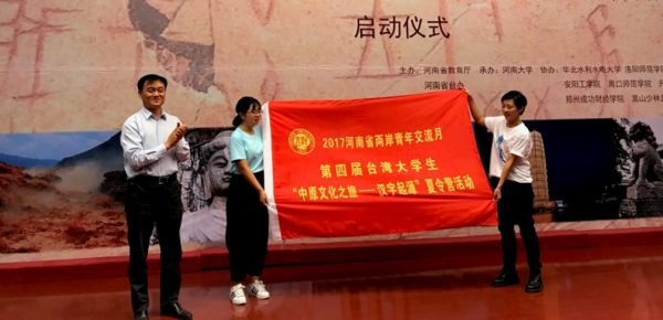 河南省台辦主任薛雲偉向參加活動的台灣學生代表授營旗