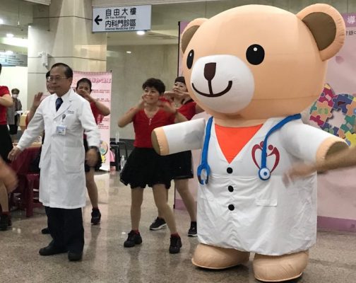 高醫院長侯明鋒(左)和器捐代言天使小麥貝兒一起做健康操，宣導器捐觀念。