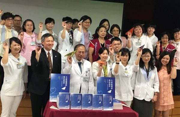 高醫院長侯明鋒(前排左三)帶領安寧療護同仁手持寫滿祝福的紙飛機，象徵「生命起飛前，高醫與你相伴」。